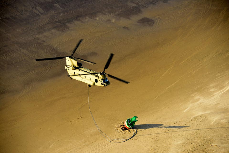 photo of helicopter lifting a buoy